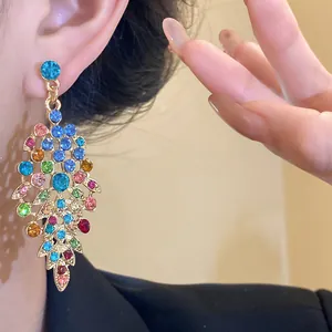 Macro detail view of colorful rhinestone leaf drop earrings with vintage palace style