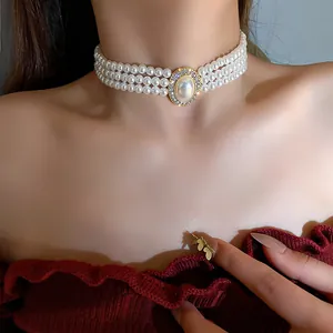 Close-up of elegant three-row pearl choker with rhinestone center piece