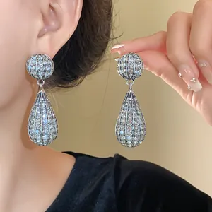 Primo piano dettagliato di eleganti orecchini pendenti in argento con strass scintillanti