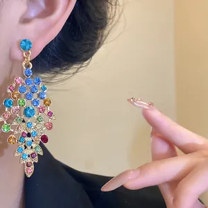 Vintage luxury colorful rhinestone leaf cluster dangle earrings shown on a model's ear