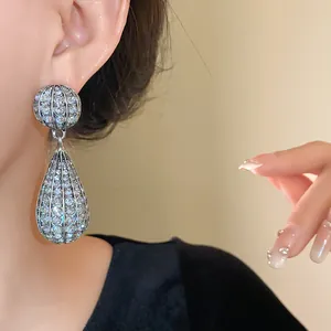 Primo piano di eleganti orecchini a goccia d'acqua color argento con strass luccicanti