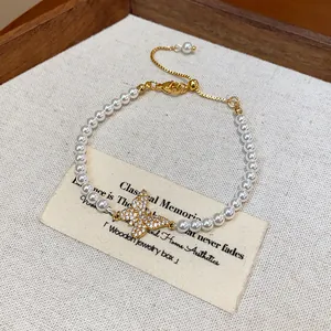 Primo piano di un bracciale di perle vintage francese con ciondolo a farfalla lucente.