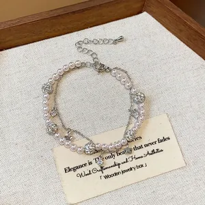 Dettaglio di un bracciale di perle vintage francese a due strati con ciondoli a stella