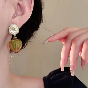 Eleganti orecchini con boccioli di rosa stabilizzati e perno in oro martellato modella