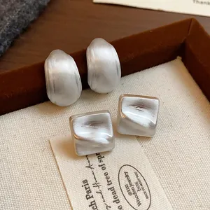Primo piano dettagliato di orecchini geometrici minimalisti in argento opaco set