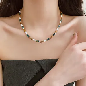 Detailed view of ethnic beaded necklace with shell beads and gold titanium steel accents