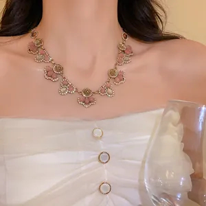 Elegant close-up of French vintage necklace with rhinestone flowers and cat-eye stones.