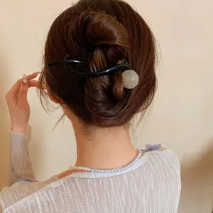 Back view of a round resin hair clip holding a bun in a Korean minimalist style.