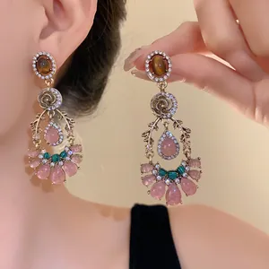 Detail view of vintage French-style earrings with pink drop stones and cat's eye gems