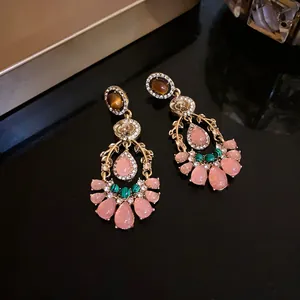 Close-up of vintage palatial style earrings with pink water-drop stones and rhinestones
