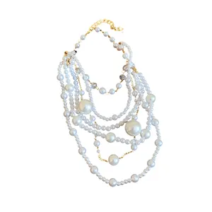 Elegant multilayered necklace with irregular faux pearls on golden chain links.