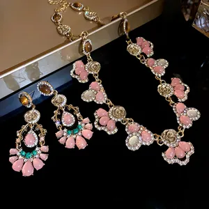 Close-up of French vintage necklace and earring set with pink cat eye stones and crystals