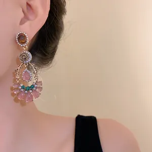 Close-up of vintage palace-style earrings with pink teardrop stones and rhinestones