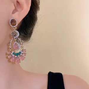 Detailed macro shot of vintage palace style dangling earrings with pink cat eye gemstones
