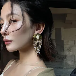 Detailed side view of vintage ethnic beaded tassel earrings worn by a model in soft light