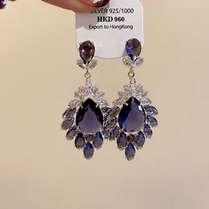 Orecchini vintage in argento S925 con zirconi blu a goccia e motivo floreale.