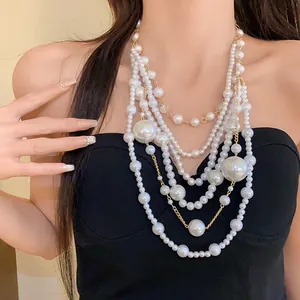 Detailed view of luxury vintage multi-layered irregular white pearl statement necklace on a model