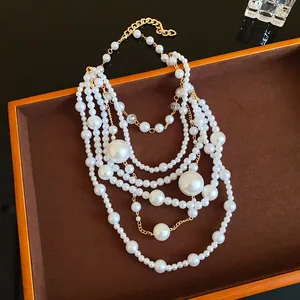 Detail shot of multi-layered pearl necklace with irregular beads on brown velvet tray