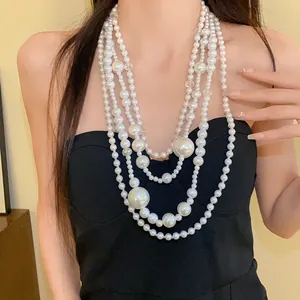 Elegant multi-layered irregular pearl necklace shown on model with black tube top dress