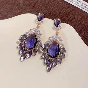 Vista dettagliata di orecchini vintage con pietre viola a goccia e zirconi brillanti