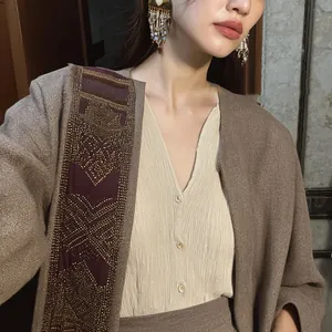 Detail view of vintage ethnic style beaded tassel earrings worn by a female model