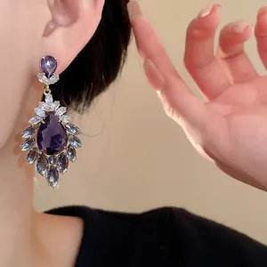 Primo piano dettagliato di orecchini vintage con zirconi viola a forma di goccia