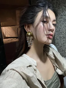 Close-up detail of vintage ethnic beaded tassel earrings worn by an elegant model