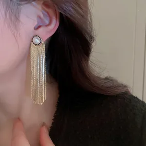 Eleganti orecchini a pendente dorati con nappa, perla e strass