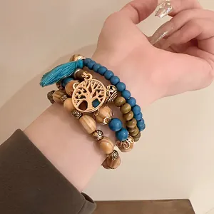 Macro view of bohemian beaded bracelet set featuring life tree charm and blue tassel