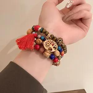 Detail shot of a bohemian multi-layer beaded bracelet with tree of life charm