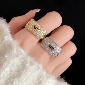 Luxurious gold and silver toned zircon square open rings featuring a central black S motif design