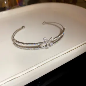 Macro view of a sparkling double-layered silver cuff bracelet with a zircon flower motif
