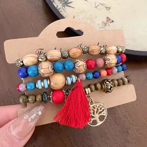 Close-up view of vintage Bohemian beaded bracelets set featuring red tassel and tree charm