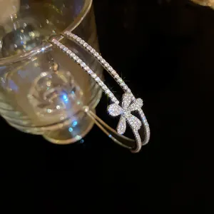 Detailed macro shot showing a sparkling flower zircon double-layer cuff bangle on glass