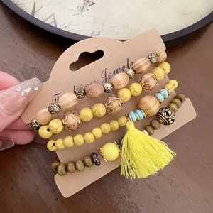 Bohemian style beaded bracelet set featuring yellow tassel and wood beads on display card