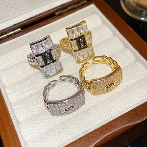 Close-up of luxury zircon square rings with chain design in gold and silver finish