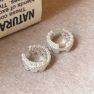 Detailed view of silver lace hoop earrings with delicate pearl accents and scalloped edges.
