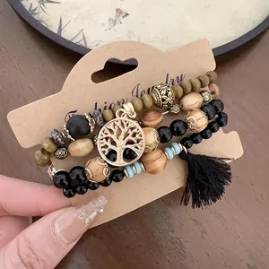 Close-up of Bohemian beaded bracelet set with tree of life charm and black tassel