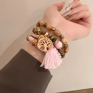 Detail view of Bohemian style beaded bracelet set featuring a Tree of Life charm and pink tassel