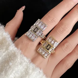 Elegant square cubic zirconia rings with chain link band shown in detail on fingers.