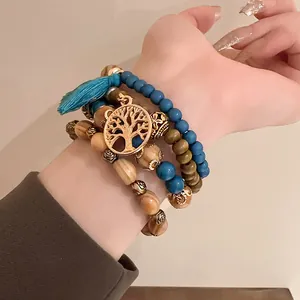 Close-up of Bohemian beaded bracelets with blue beads, tree of life charm and tassel detail.