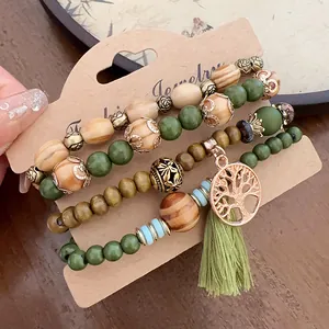 Bohemian beaded bracelet set featuring wood beads, tree of life charm and green tassel