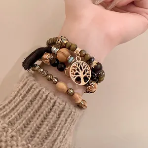 Detailed close-up of bohemian beaded bracelet set with tree of life charm and black tassel