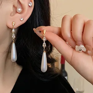 Elegante vergoldete Quastenohrringe mit funkelnden Zirkonia und weißen Tropfenperlen