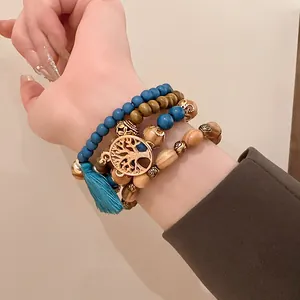 Close-up of Bohemian beaded bracelet set with tree of life charm and blue tassel.