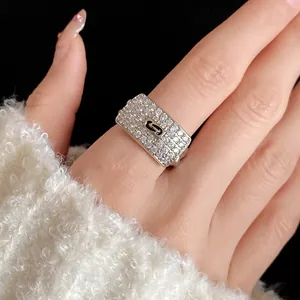 Detailed view of silver rectangular ring with pavé zircons and black S-link design