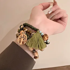 Close-up of Bohemian multi-layer beaded bracelet with tree of life and tassel charm