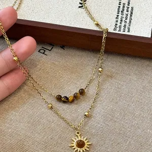 Vintage gold layered necklace featuring tiger eye beads and a sunflower pendant.