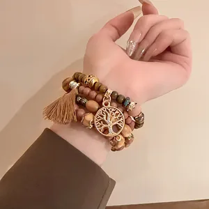 Detail shot of bohemian beaded bracelet stack with tree of life pendant and tassel decoration