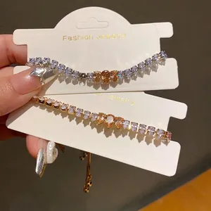 Elegant zircon heart chain bracelets in gold and silver finish on display cards.